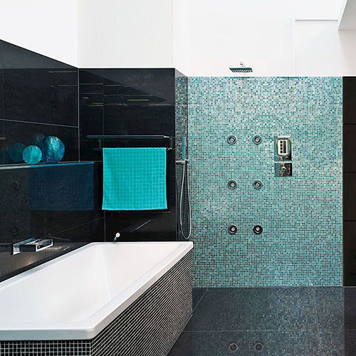 Die Badewanne und die Dusche sind mit Mosaikfliesen verkleidet, was ihnen eine interessante und edle Optik verleiht.