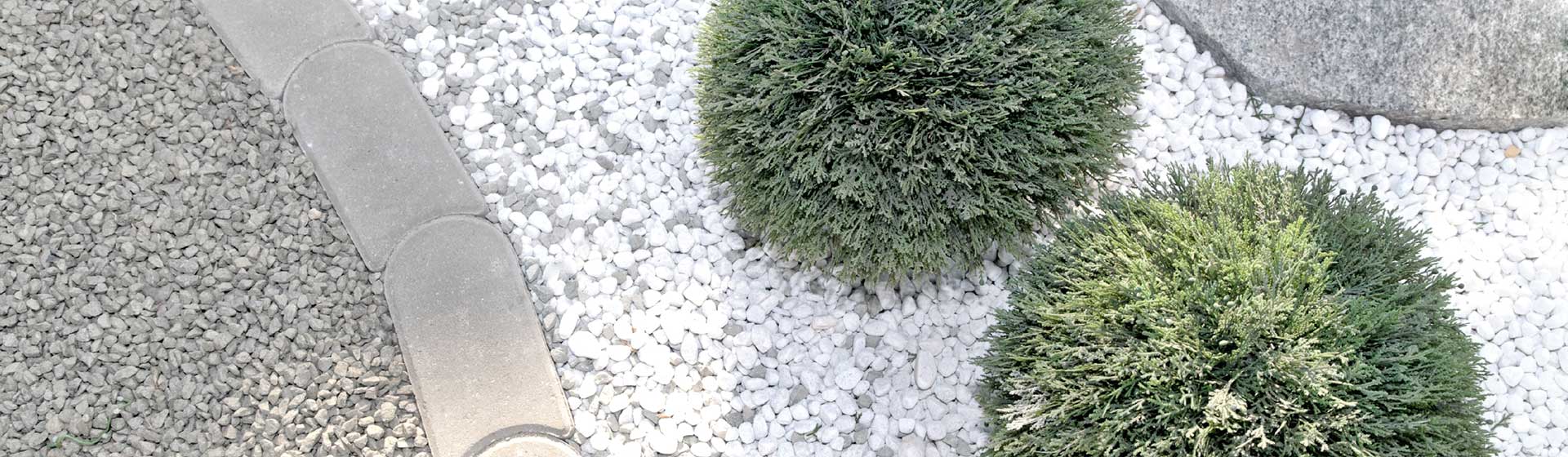 In unserer Ausstellung für Garten- und Landschaftsbau sind Zierkiese und Rasenkantensteine zu sehen. Hier wurde beispielsweise weißer Kies mit grauen Rasenkantensteinen kombiniert.