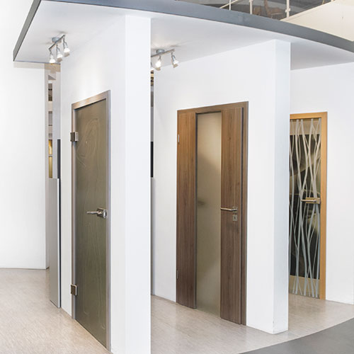 Auf diesem Bild ist eine Auswahl an Zimmertüren in Originalgröße zu sehen, die in Musterwände integriert sind. Sie geben einen Eindruck von den verschiedenen Designs und Materialien unserer Türenausstellung in Hildesheim. Die Ausstellung umfasst moderne Ganzglastüren, klassische Holzzimmertüren sowie Varianten mit eleganten Glasausschnitten. Jedes Modell ist so eingebaut, dass Besucher einen realistischen Eindruck von Optik und Verarbeitung erhalten.
